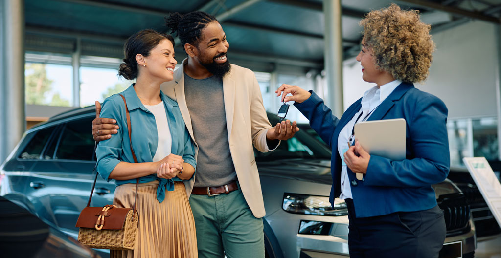 Couple discutant budget achat voiture devant citadine occasion